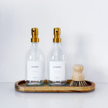 Load image into Gallery viewer, Set Of 2 Clear Bottles - Glass Or Plastic - Hands & Dishes - Gold Metal Pumps