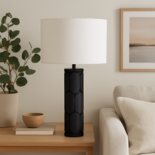 Load image into Gallery viewer, Aurelia black mango wood table lamp base with white linen shade on a oak side table in a living room.