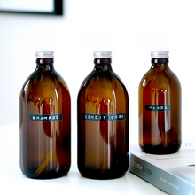 Load image into Gallery viewer, Amber Glass Or Plastic Bottle With Stamped Label &amp; Silver Metal Screw Lid
