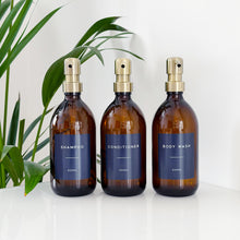 Load image into Gallery viewer, Set Of 3 Amber Bottles - Glass Or Plastic - Dark Blue Labels - Brushed Gold Metal Pumps
