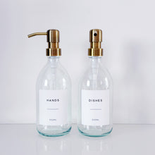 Load image into Gallery viewer, Set Of 2 Clear Bottles - Glass Or Plastic - Hands &amp; Dishes - Brushed Light Gold Metal Pumps
