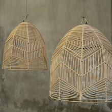 Load image into Gallery viewer, Two Bala mediterranean-style woven rattan light shades hanging in front of a concrete wall 
