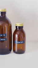 Load and play video in Gallery viewer, Amber Glass Or Plastic Bottle With Stamped Label &amp; Gold Metal Screw Lid
