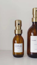 Load and play video in Gallery viewer, Amber Glass Or Plastic Dispenser Bottle With Personalised Label &amp; Light Brushed Gold Metal Pump

