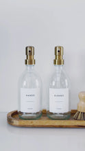 Load and play video in Gallery viewer, Set Of 2 Clear Bottles - Glass Or Plastic - Hands &amp; Dishes - Brushed Light Gold Metal Pumps
