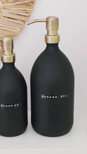 Load and play video in Gallery viewer, Matt Black Glass Dispenser Bottle With Stamped Personalised Label &amp; Light Brushed Gold Metal Pump
