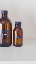 Load and play video in Gallery viewer, Amber Glass Or Plastic Bottle With Stamped Label &amp; Black Metal Screw Lid
